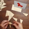 Adulto armando la figura del caballo usando el lado B de la tarjeta del juego "Un desafío para tu mente" de Trianguland