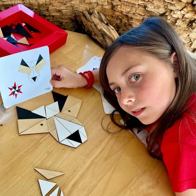 Niña mostrando la figura que armó con el puzzle libre de Trianguland.